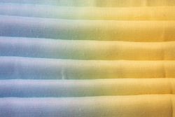 Gradient colorful folded fabric background texture. blue yellow and green.