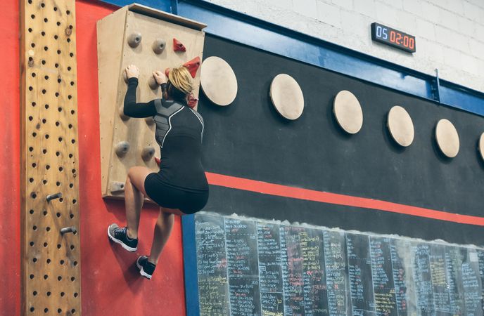 Woman hanging on the climbing wall
