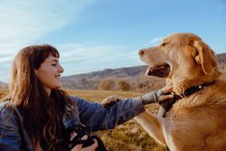 Woman taking photo of dog between field