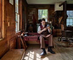 Costumed interpreter at work at the shoeshop at Old Sturbridge Village, Sturbridge, Massachusetts