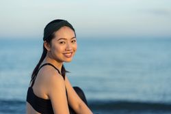 Sportive woman sitting in the on beach