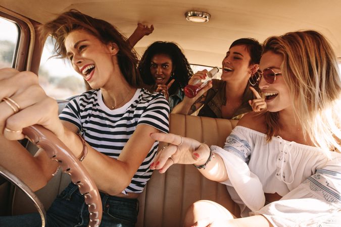 Group of friends having fun being silly and traveling in car