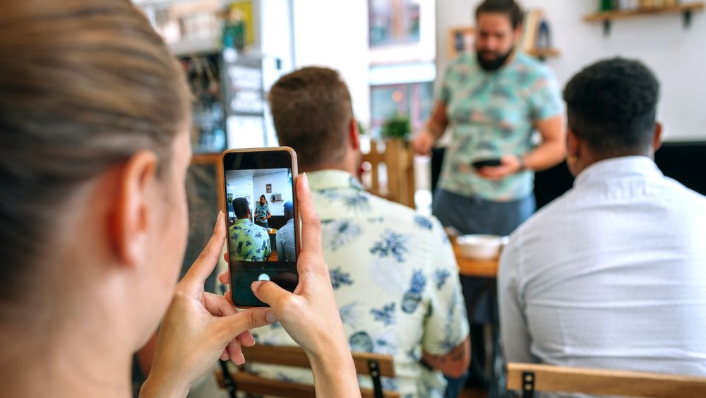 Woman taking photo with mobile in a cooking workshop