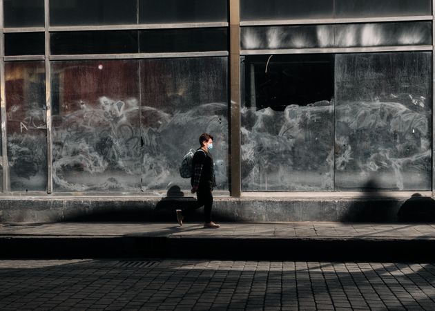 Woman in facemask walking down quiet street in Mexico City