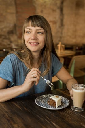 Woman holding spoon with slice of cake