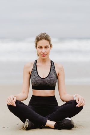 Woman meditating on the beach