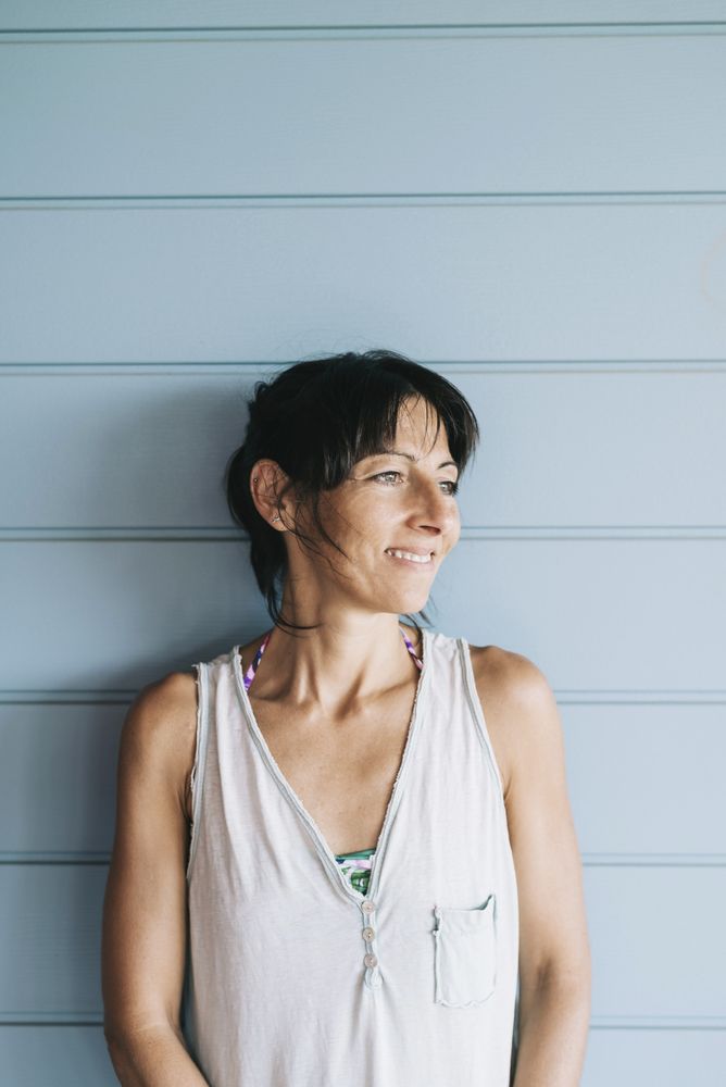 Portrait of wistful woman with ponytail leaning on wood wall outside