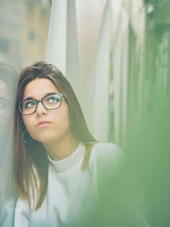 Young woman with standing against glass