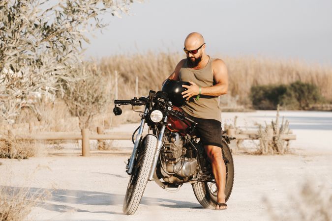 Serious male driving motorcycle in forest