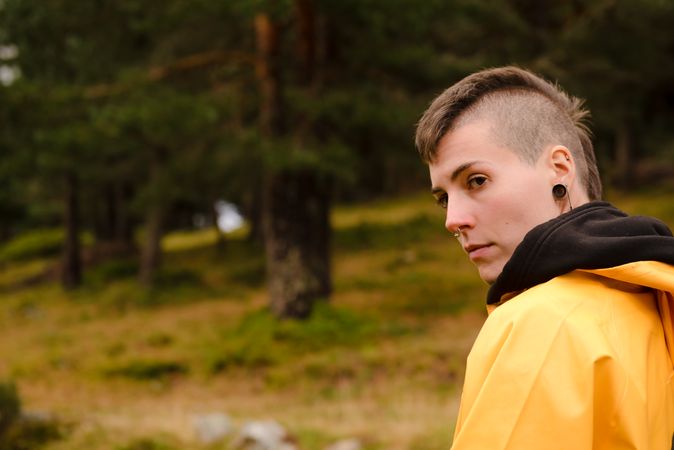 Person in yellow raincoat walking in forest