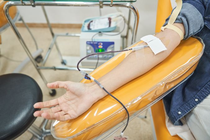 Unrecognizable female patient donating blood in hospital