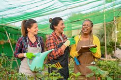 Cheerful diverse women in hothouse