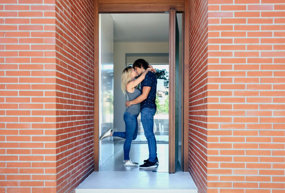 Couple kissing at the entrance