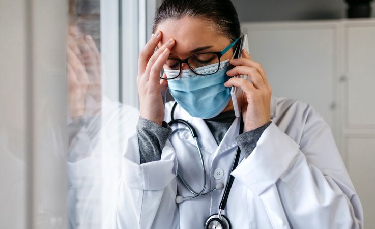 Worried female doctor talking on the phone