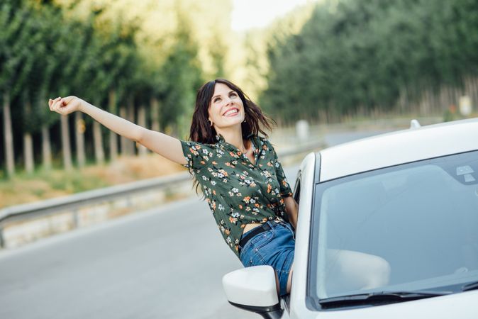 Happy brunette female waving outside passenger window