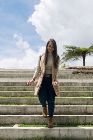 Woman in warm clothes walking down stone stairs