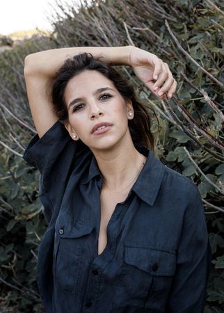 Tranquil woman in stylish clothing delighting in forest