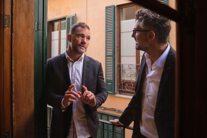 Friends in suits talking and looking at each other