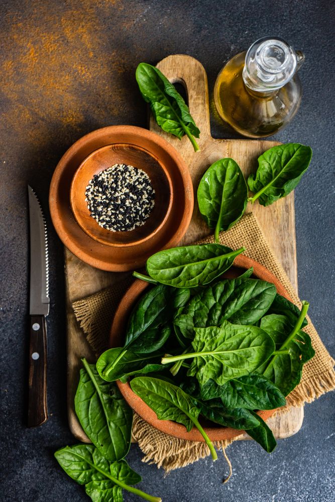 Organic food concept with fresh spinach in terracotta bowl
