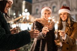 Friends lighting sparklers together during a Christmas or New Year's Eve party.