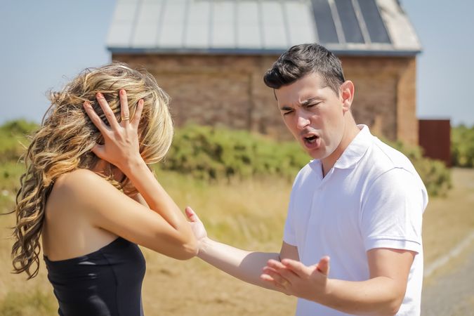 Man shouting and woman cover her ears in a quarrel