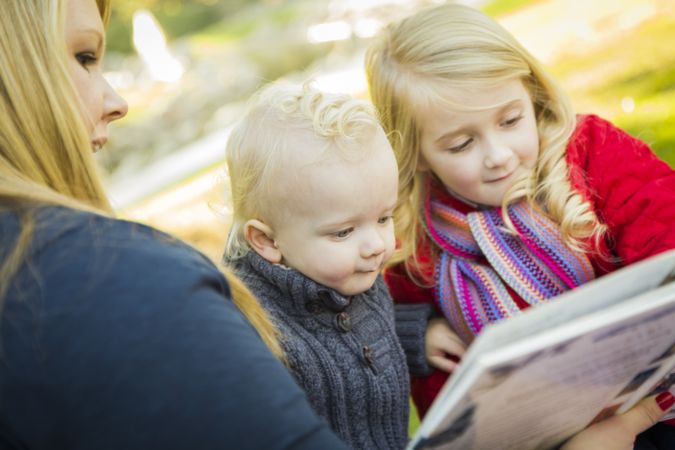 Mother Reading a Book to Her Two Adorable Blonde Children.