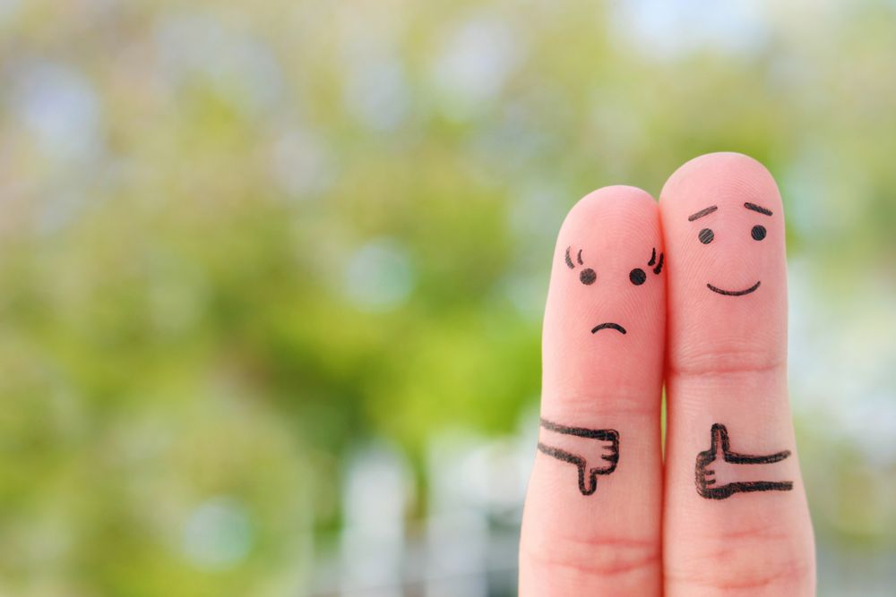 Fingers art of couple. Woman showing thumb down and man showing thumb up. Concept of disagreement in family.