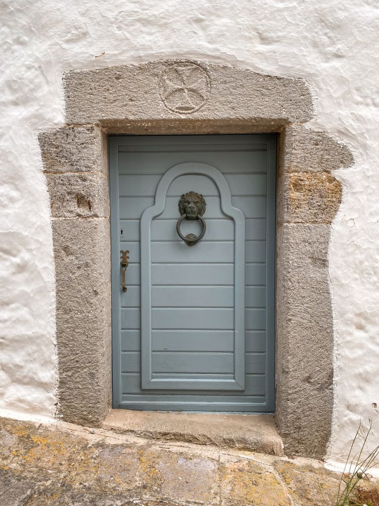 Patmian grey door with lions head knocker