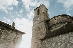 Tower near brick building and cloudy sky