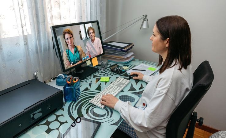 Woman talking on video call with her mother and doctor giving medical report