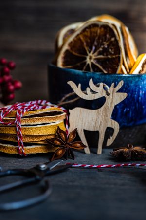 Side view of slices of dried orange in blue mug on Christmassy table