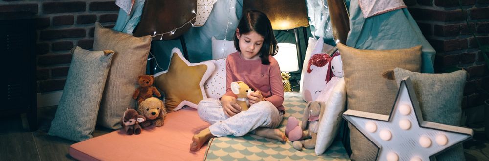 Girl playing with stuffed animals in a teepee
