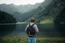 Anonymous man enjoying mountain landscape and lake