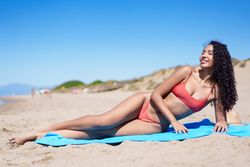 Model Sunbathing on the Beach in Fashionable and Stylish Swimwear, Enjoying the Sun