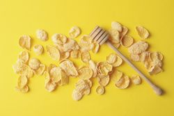 Tasty muesli and dipper on yellow background