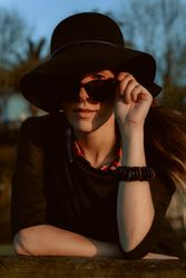Dreaming stylish woman in sunglasses and hat