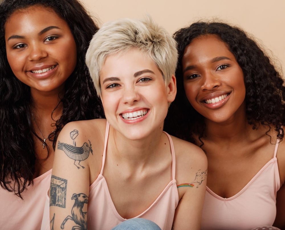 Group portrait of three diverse women smiling in the studio