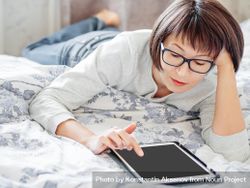 Woman with tablet on bed 5zX3mb
