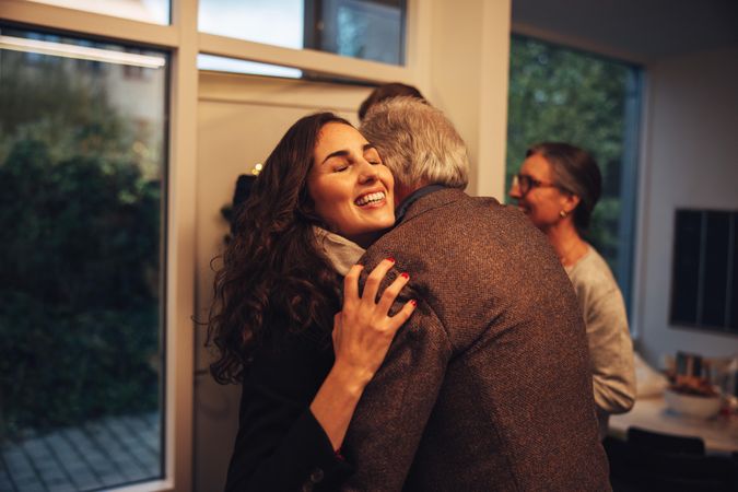Grandfather hugging daughter while visiting for the holidays