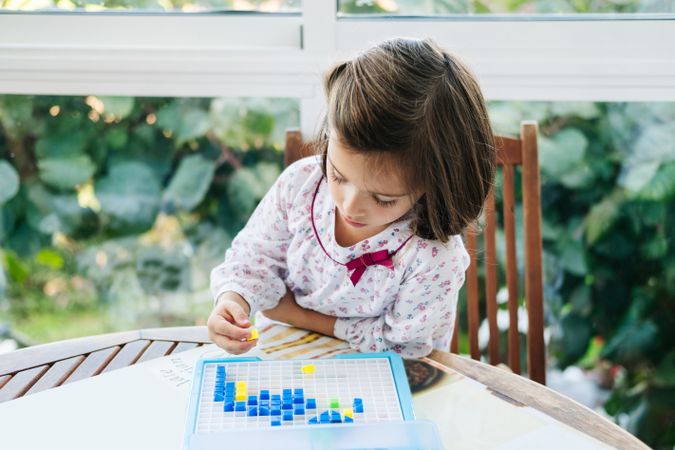 Girl playing with mosaic board game