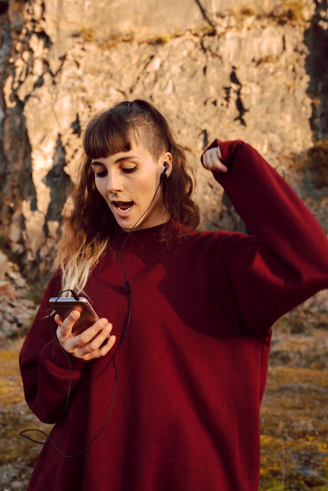 Young woman with smartphone dancing