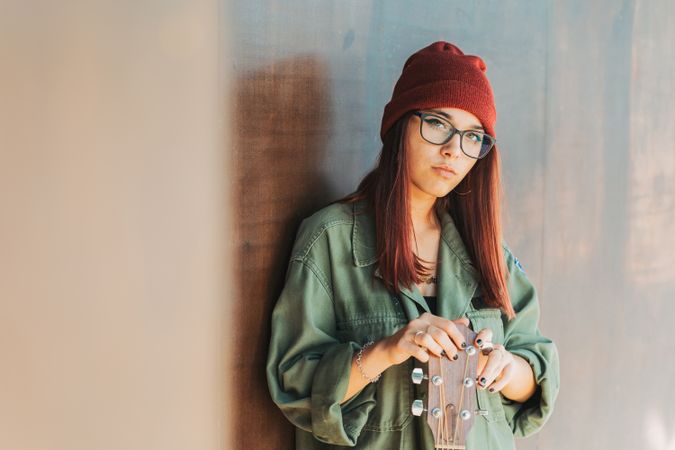 Woman in glasses leaning on wall