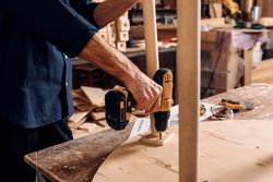 Male hand using a drill on a table