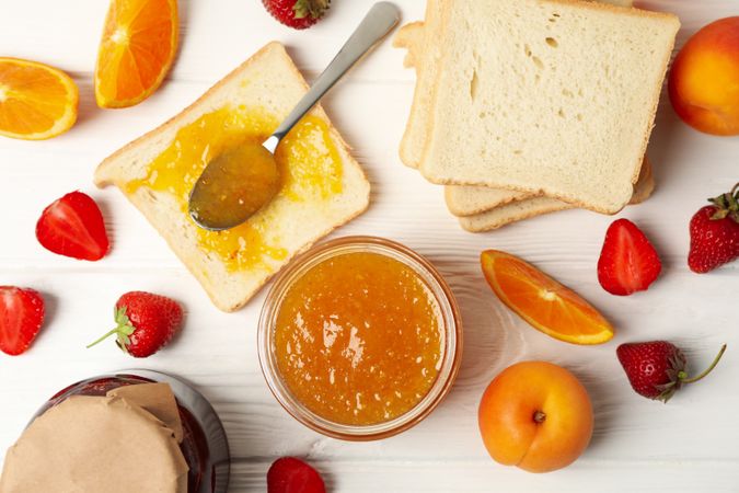 Composition with apricot jam on wooden background. Sweet breakfast