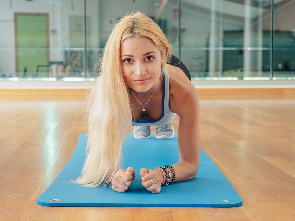 Young sportswoman performing plank