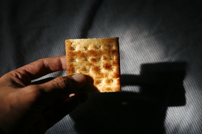 Person holding cracker in morning light