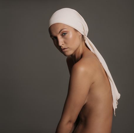 Side view of female model posing scarf on her head