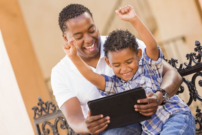 Happy Black Father and Son Using Tablet On Balcony