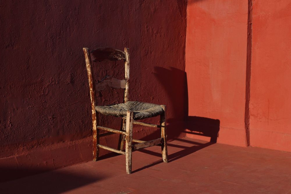 Old wooden one vintage chair in a room with red grunge walls