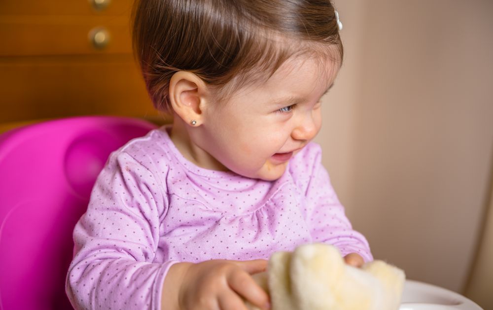 Happy baby laughing and playing with a toy sitting